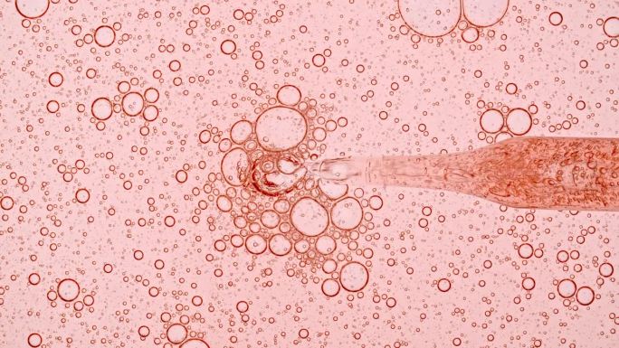 透明化妆品凝胶流体与分子气泡油分布。显微镜下的细胞泡簇。天然有机化妆品、药品微距拍摄。生产特写。缓慢