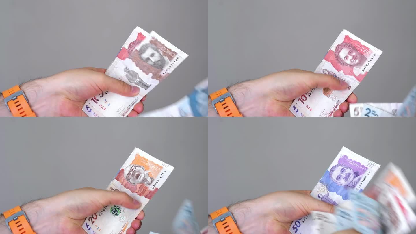 视频中两只手握着不同面额的哥伦比亚钞票