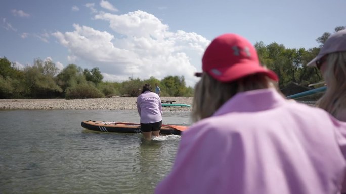 一群朋友正走向河边玩桨板