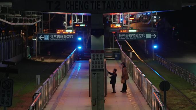 夜晚母亲带着儿子在武汉光谷有轨电车站等车