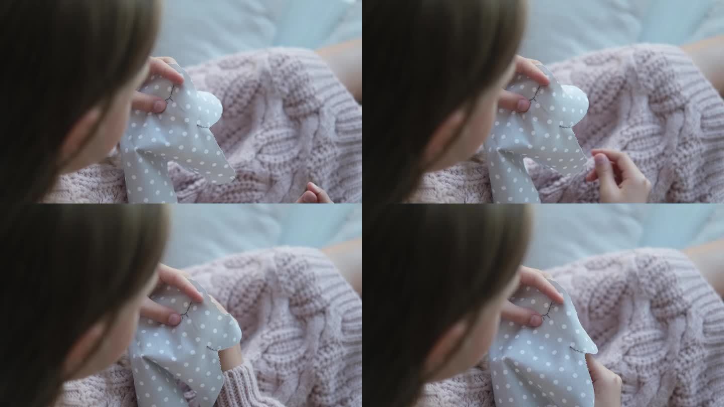 小孩手缝毛绒玩具的特写镜头。这个女孩缝了一个柔软的大象玩具。手工制作的,爱好。