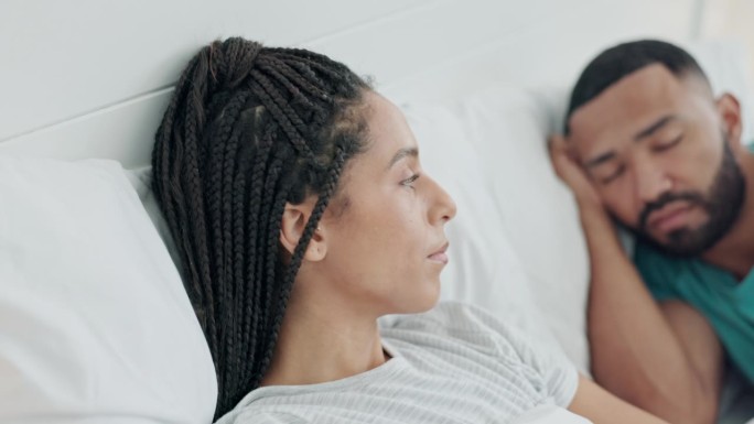 夫妻，失眠和女人在床上焦虑担心分手，危机和内疚在家里。心理健康、抑郁和悲伤的女性和男性在争吵、打架和