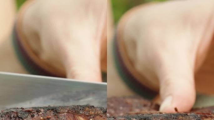 我在砧板上用刀把一块牛排切成两半，特写镜头，中等熟度。垂直视频。