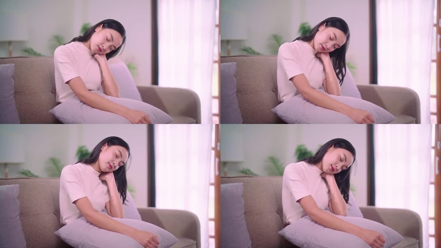 一个亚洲女人在家里的沙发上以错误的姿势做颈部自我按摩，有身体肌肉问题和保健观念的人。