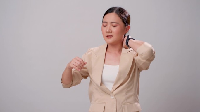 一名亚洲女子独自站在白色背景上，感到颈部疼痛。