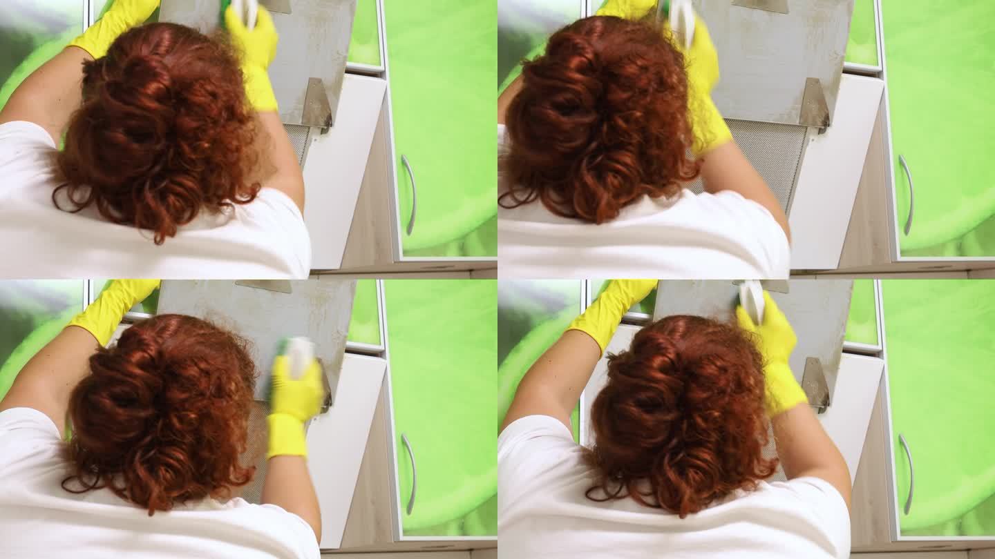 清洁和清洗白色厨房罩。一个女人的手在擦去头巾上的污垢和油脂的特写。