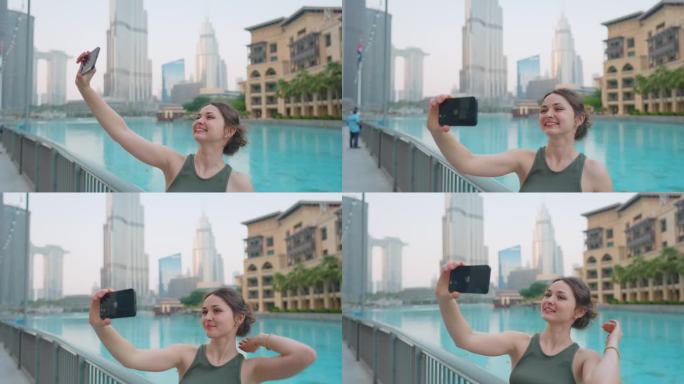 一名女子在迪拜喷泉附近用智能手机拍照