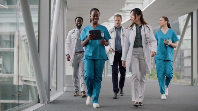 大堂，走路和医生用平板电脑，说话和团队合作用在线报告，成功和合作。人，医疗专业人员或工作人员与健康，