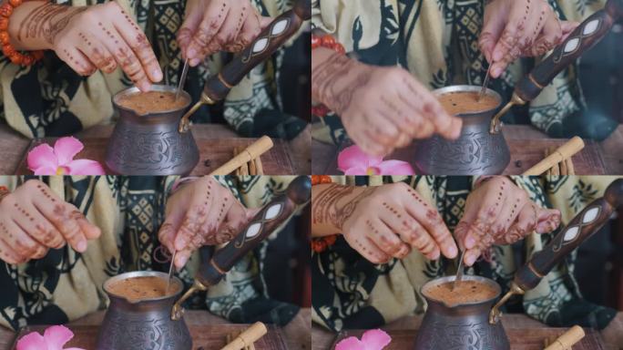 印度妇女用手加入香料、糖和茶匙搅拌印度茶。