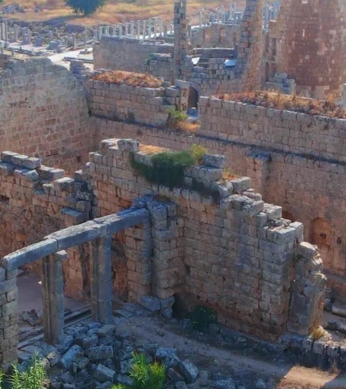 垂直视频。故事的格式。在这个迷人的空中库存视频中，展示了土耳其安塔利亚当代城市佩尔热古城的非凡废墟。