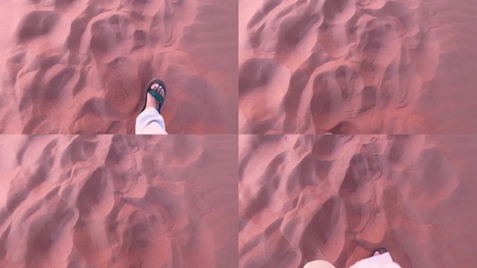 在约旦瓦迪拉姆的红色沙漠中，穿着凉鞋走在红色的沙滩上