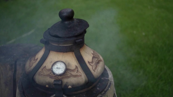 近距离烟雾从现代陶瓷柴火tandoor在户外厨房。