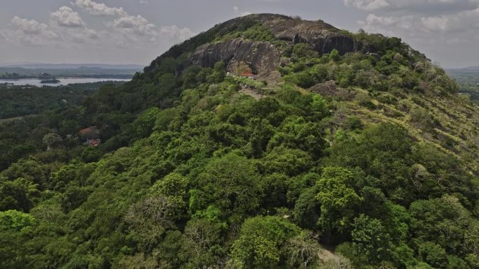 空中v4电影无人机飞越Isigili山，捕捉山坡上的皇家洞穴寺庙和热带丛林景观的黄金寺庙-用Mavi