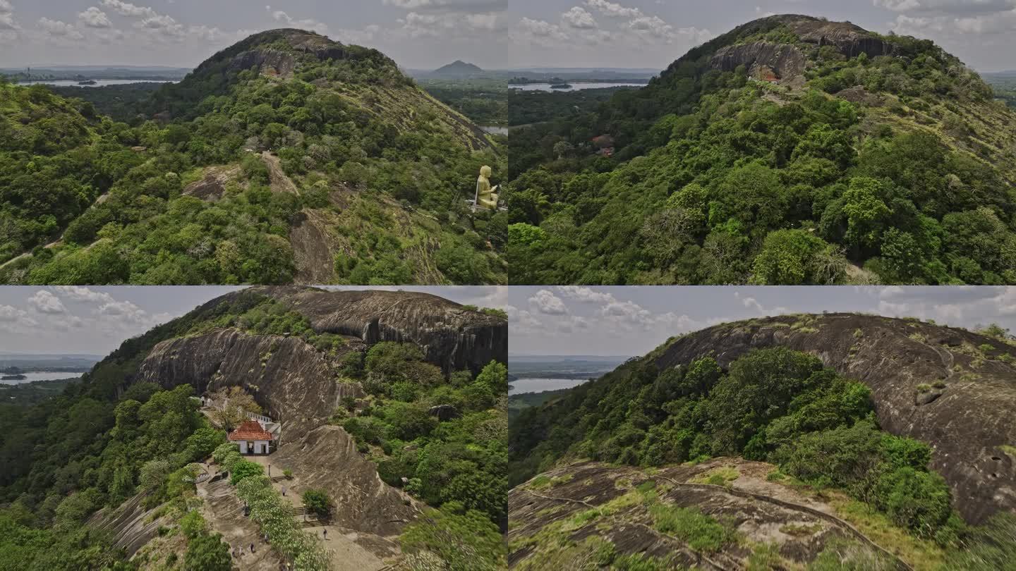 空中v4电影无人机飞越Isigili山，捕捉山坡上的皇家洞穴寺庙和热带丛林景观的黄金寺庙-用Mavi