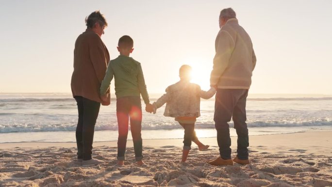 家人手牵着手，祖父母和孙子孙女在海滩上，日出和大自然，背景和海洋。爱，关心和支持，假期和团结，老人和