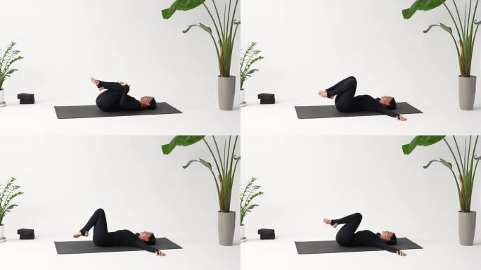 练习瑜伽的女性练习帕瓦那动作，放松体式，增强腹部肌肉，穿着运动工作服，躺在工作室的垫子上训练