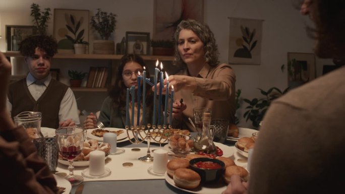 犹太妈妈在家庭晚餐上点燃蜡烛