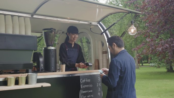 日本商人在移动咖啡拖车上付款