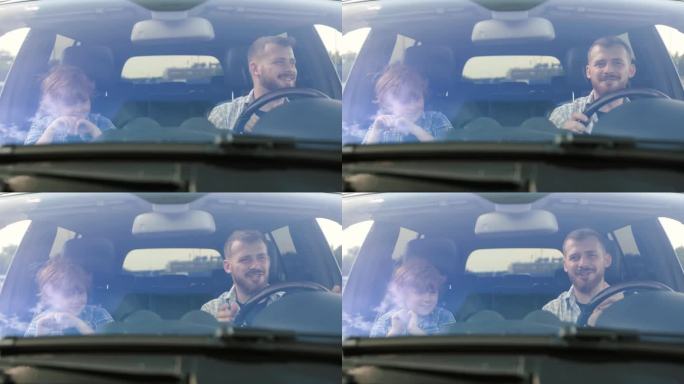 快乐的父亲和他的小儿子在汽车里跳舞。慢动作