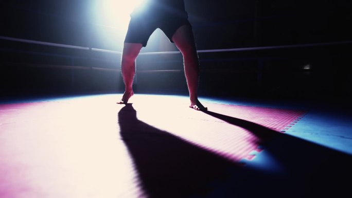 赛前拳台内拳手的腿廓在空中挥拳，戏剧性地成为人们训练格斗运动的焦点