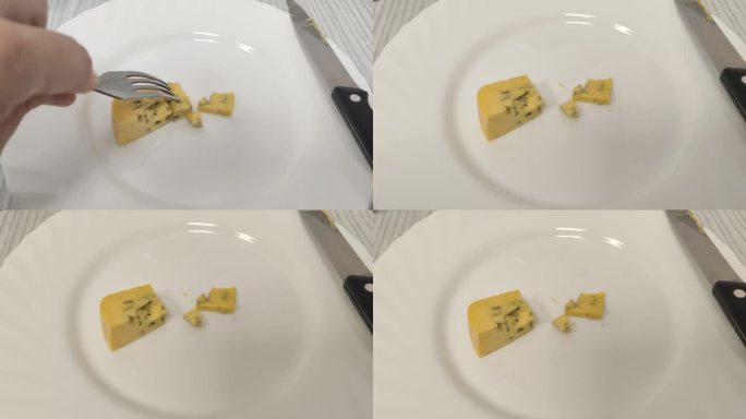 一个人用叉子吃着黄蓝奶酪。第一人称观看视频