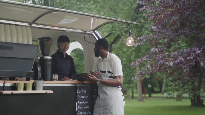 两个咖啡拖车的咖啡师，一起使用数码平板电脑