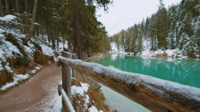SLO MO木质栏杆沿着人行道和平静湖周围的森林在冬天在白云石