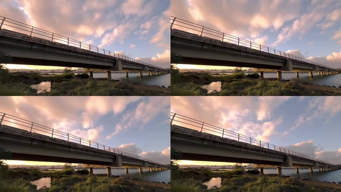 迷人的延时拍摄序列，不断变化的云舞在混凝土桥的坚固背景下展开，优雅地横跨整个场景。