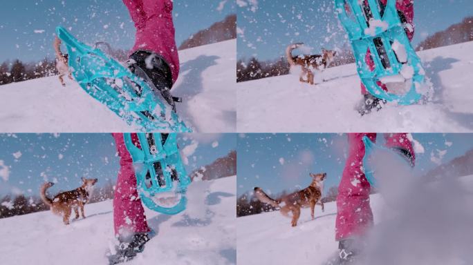 慢动作，低角度:女士和她的狗在雪地里奔跑