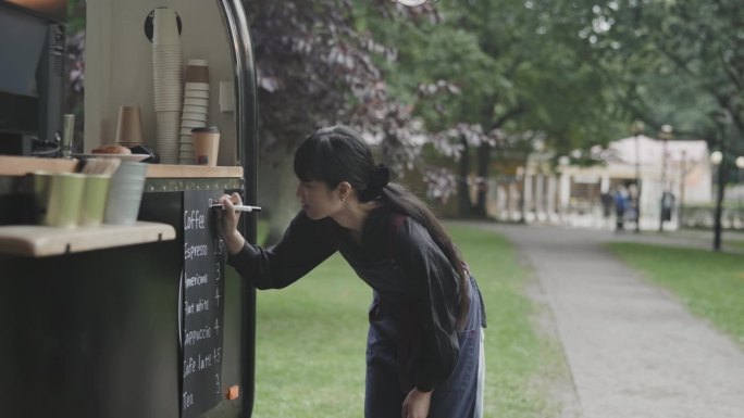 日本咖啡师在她的咖啡拖车上写菜单