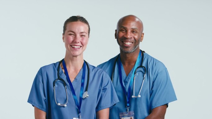 工作室拍摄微笑的男性和女性医生在实习医生在白色背景