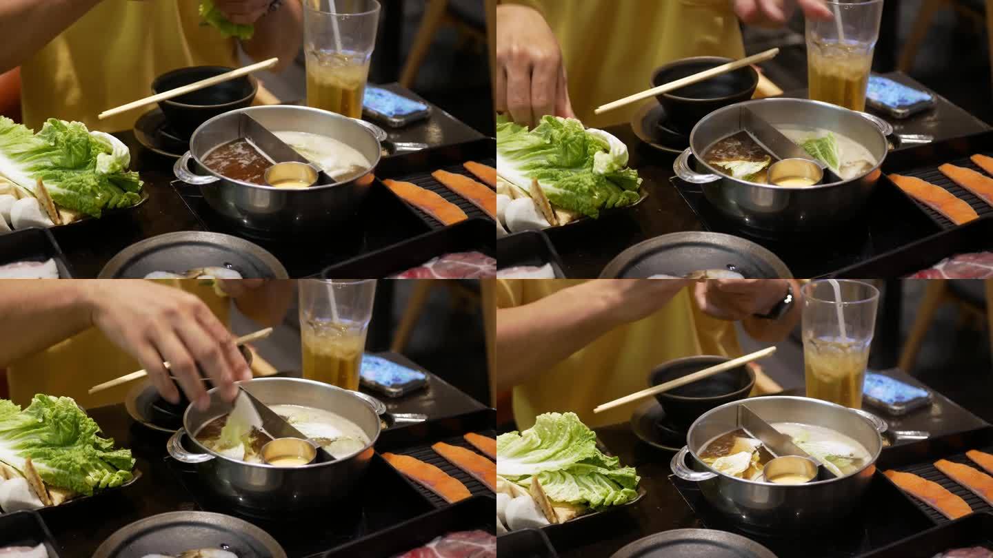 火锅涮锅与多种蔬菜在沸腾的火锅汤中烹煮的特写。日本亚洲美味健康火锅涮食品