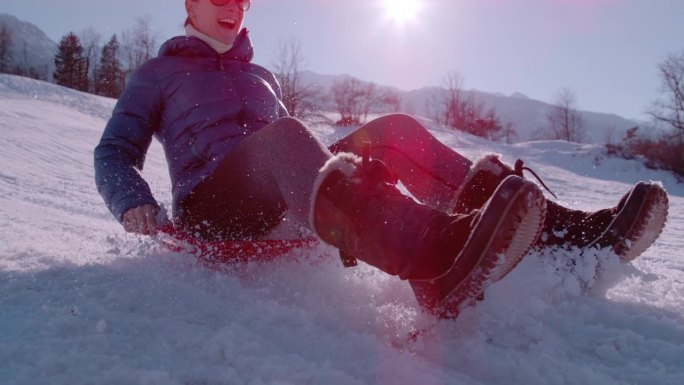 慢镜头，特写:快乐的年轻女子享受着从雪山上滑下的乐趣