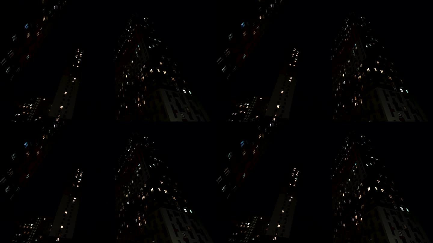夜景高层住宅，窗户透光。行动。夏夜静悄悄的城市，底层看住宅楼。