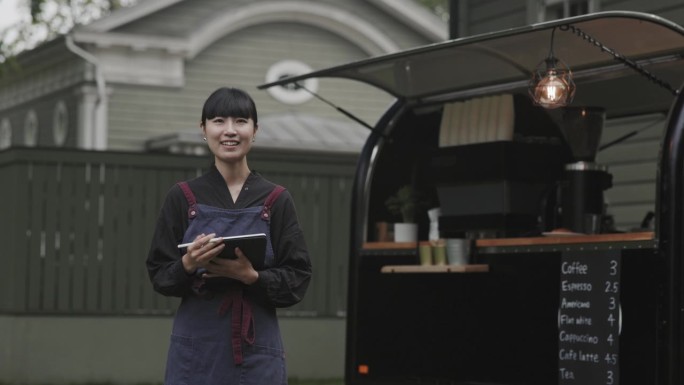 日本咖啡师在她的咖啡拖车旁的肖像
