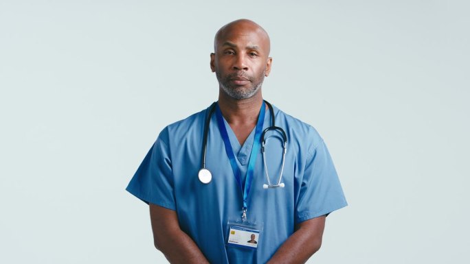 工作室肖像严肃成熟的医生或护士穿着工作服对白色背景