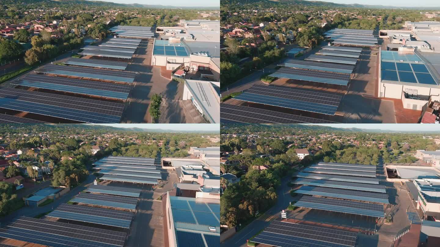 空中特写。太阳能电池板在南非的一个购物中心提供了一个阴凉的停车场，住宅郊区的视野。气候变化，全球变暖