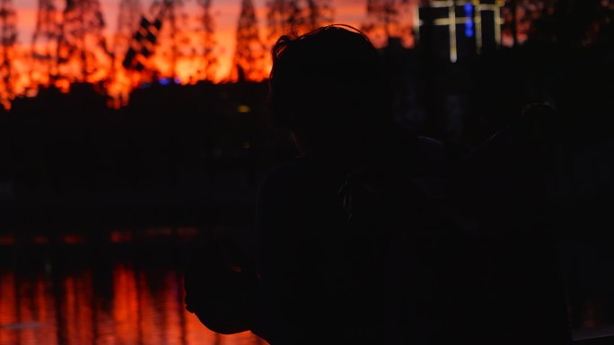 夕阳下湖边思考的男人