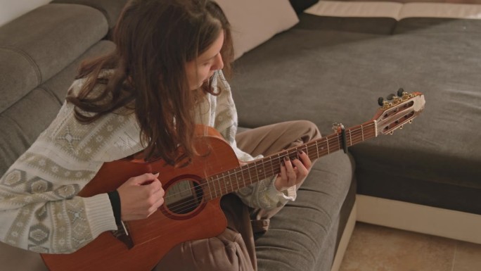 年轻女子学习弹吉他在家里-股票视频