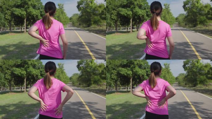 在当地的一个跑步公园，一名女跑步者在晨练后抓着背部缓解背部疼痛