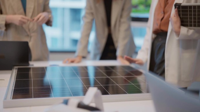一群年轻的工程师正在一个绿色能源项目中共同研究太阳能电池板。