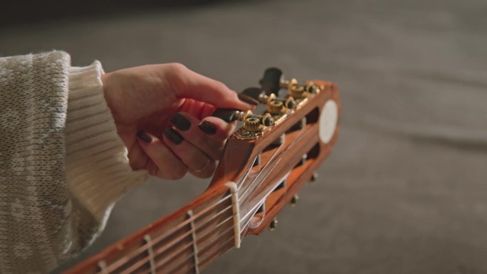 一个女人的手的特写，而调整吉他-股票视频