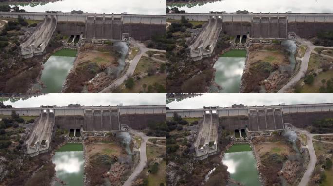 西班牙瓦伦西亚省用于灌溉和蓄水的Bellús重力坝前面的全景无人机视频，安全阀满负荷运行