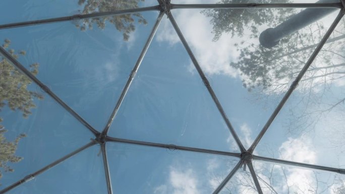 在一个美丽的春日阳光明媚的日子里，在森林中央的爱彼迎球形房屋内，用4k拍摄的一幅时间推移图。