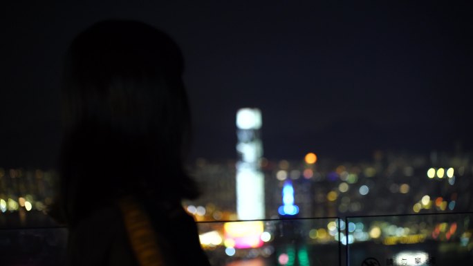 夜晚游客女性站在太平山顶上看香港夜景风景