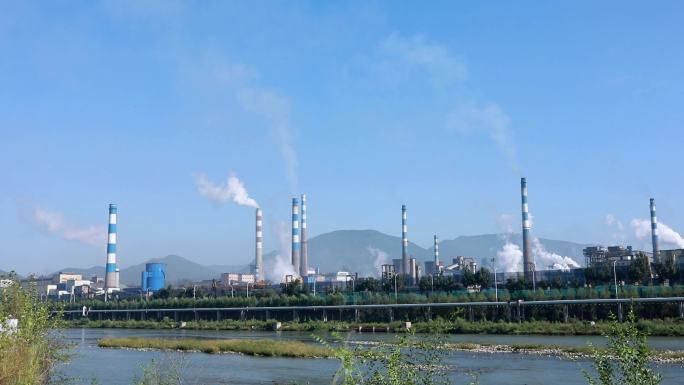 延时拍摄蓝天下冒着白烟的钢厂外景