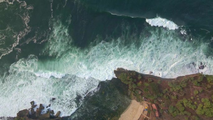 海滨的鸟瞰图。海浪拍打着海岸线。无人机俯瞰热带海滩，海浪破碎——印度尼西亚