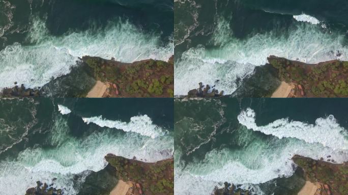 海滨的鸟瞰图。海浪拍打着海岸线。无人机俯瞰热带海滩，海浪破碎——印度尼西亚
