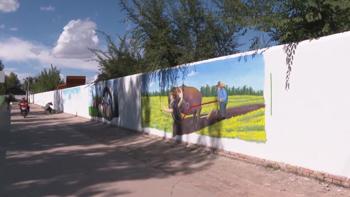 画家在农村围墙上作画美化环境村容村貌