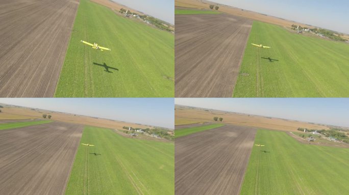 小型作物喷粉机掠过乡村草地跑道的FPV无人机视图